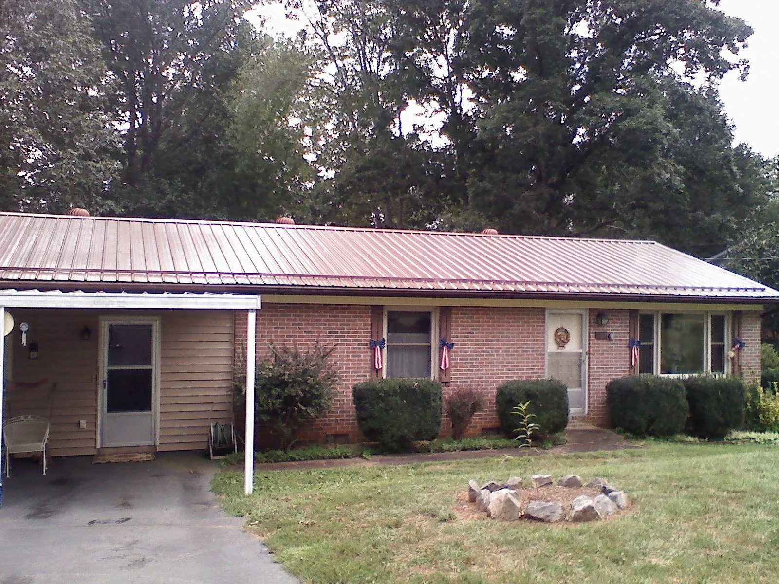 Bronze metal roof and carport on a brick ranch home — Roof Repair work by our crew in Springville